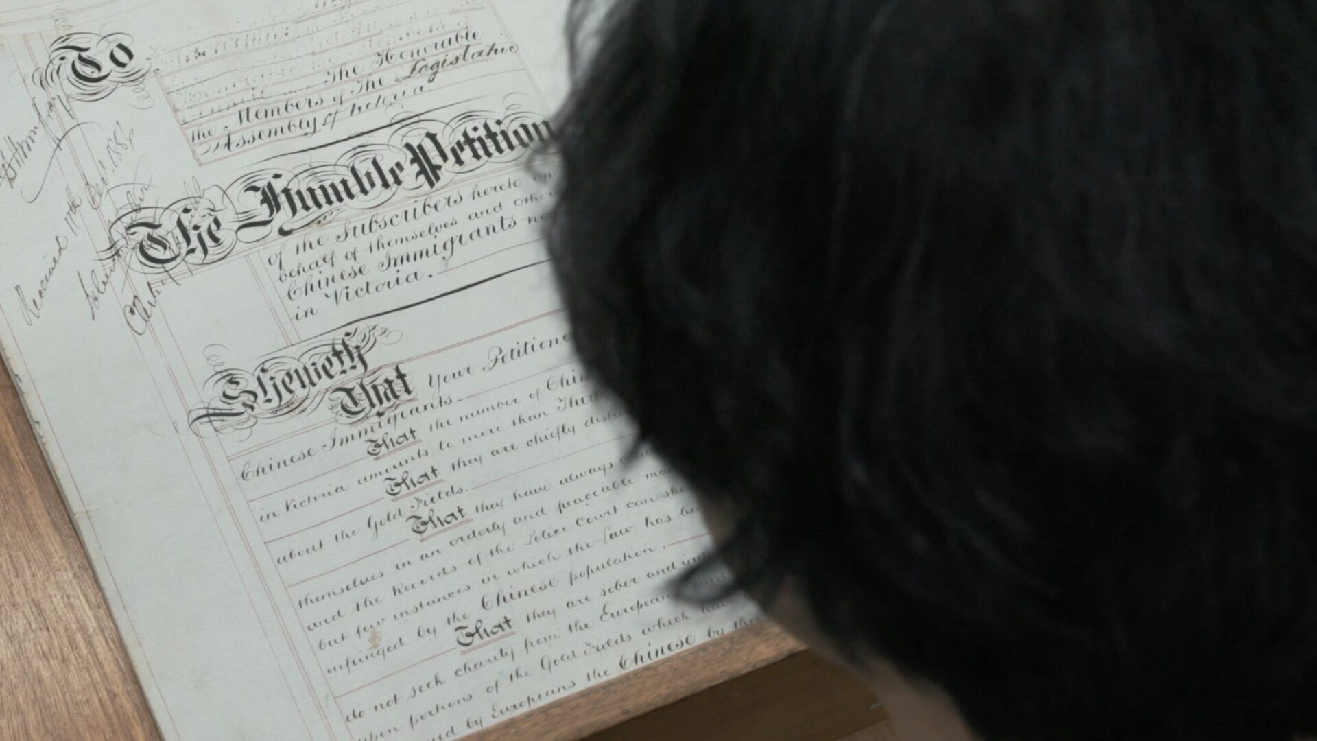 A Chinese man reading The Humble Petition by Chinese gold miners to protest the 1855 immigration tax.