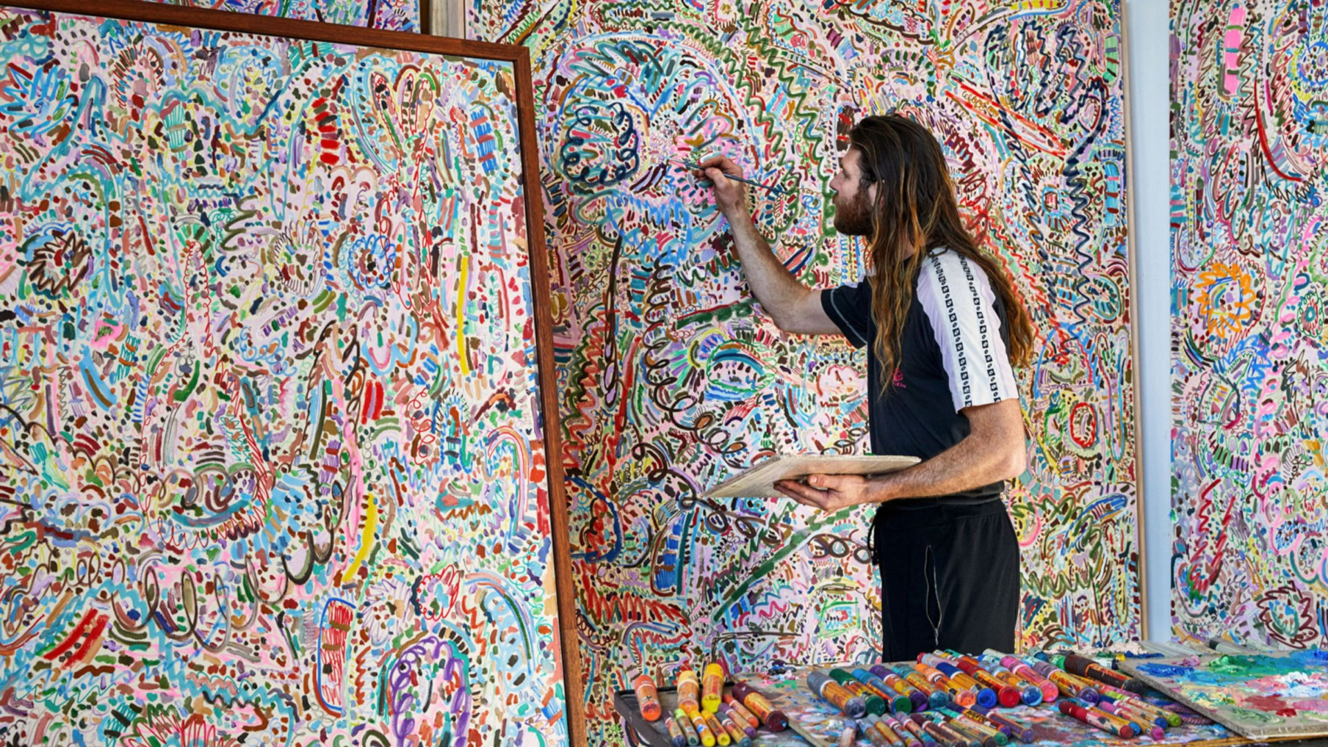 Photo of artist painting in their studio.